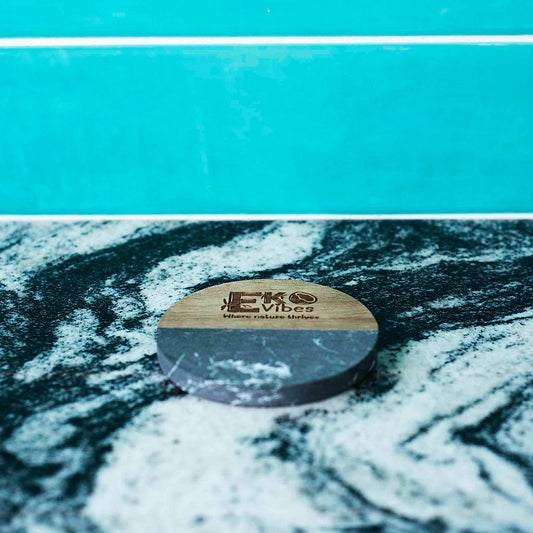 Juodo marmuro ir medžio apvalus padėkliukas gėrimams