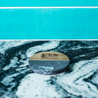 Juodo marmuro ir medžio apvalus padėkliukas gėrimams