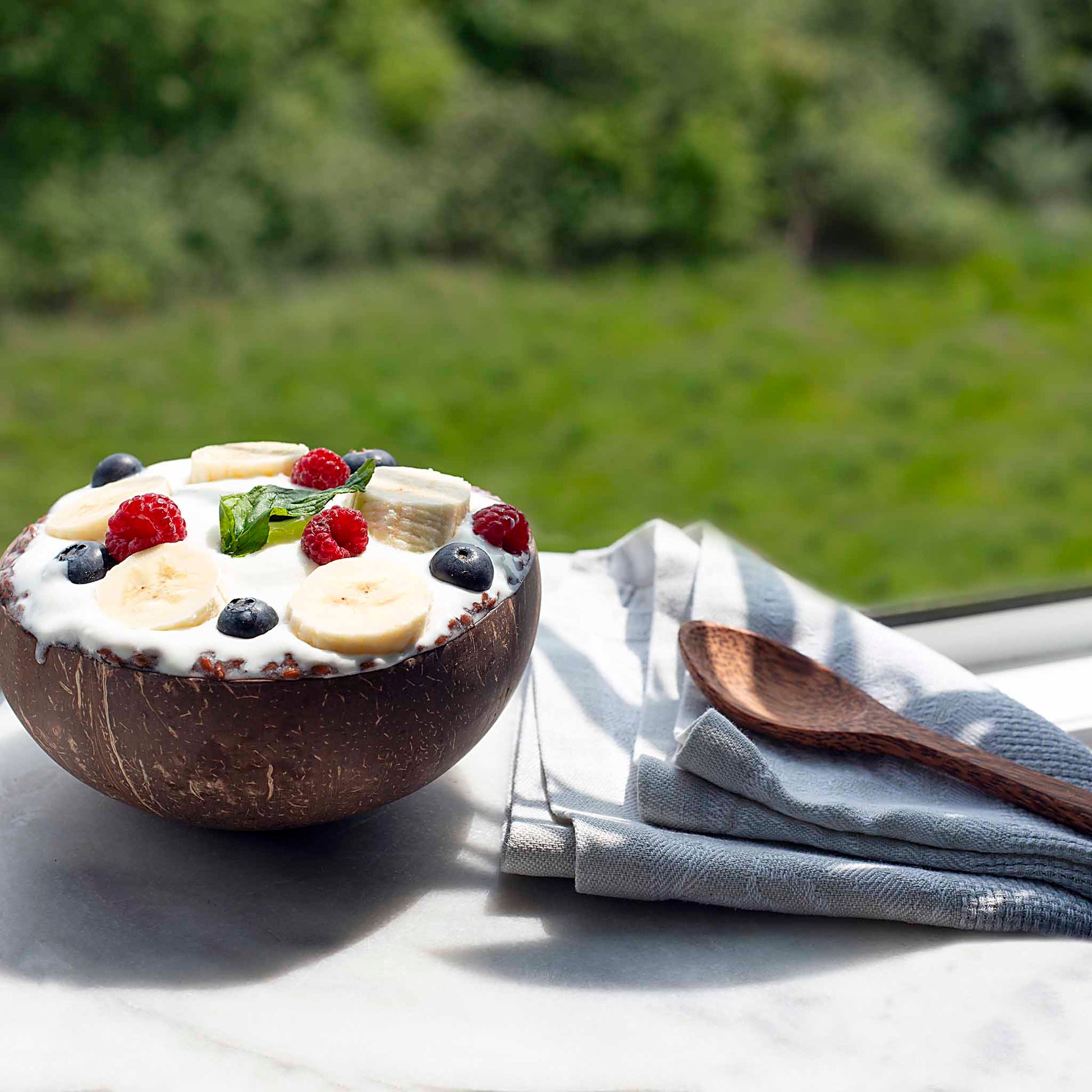Rankų darbo kokoso dubuo MAXI ant staliuko gamtoje – išskirtinis virtuvės akcentas