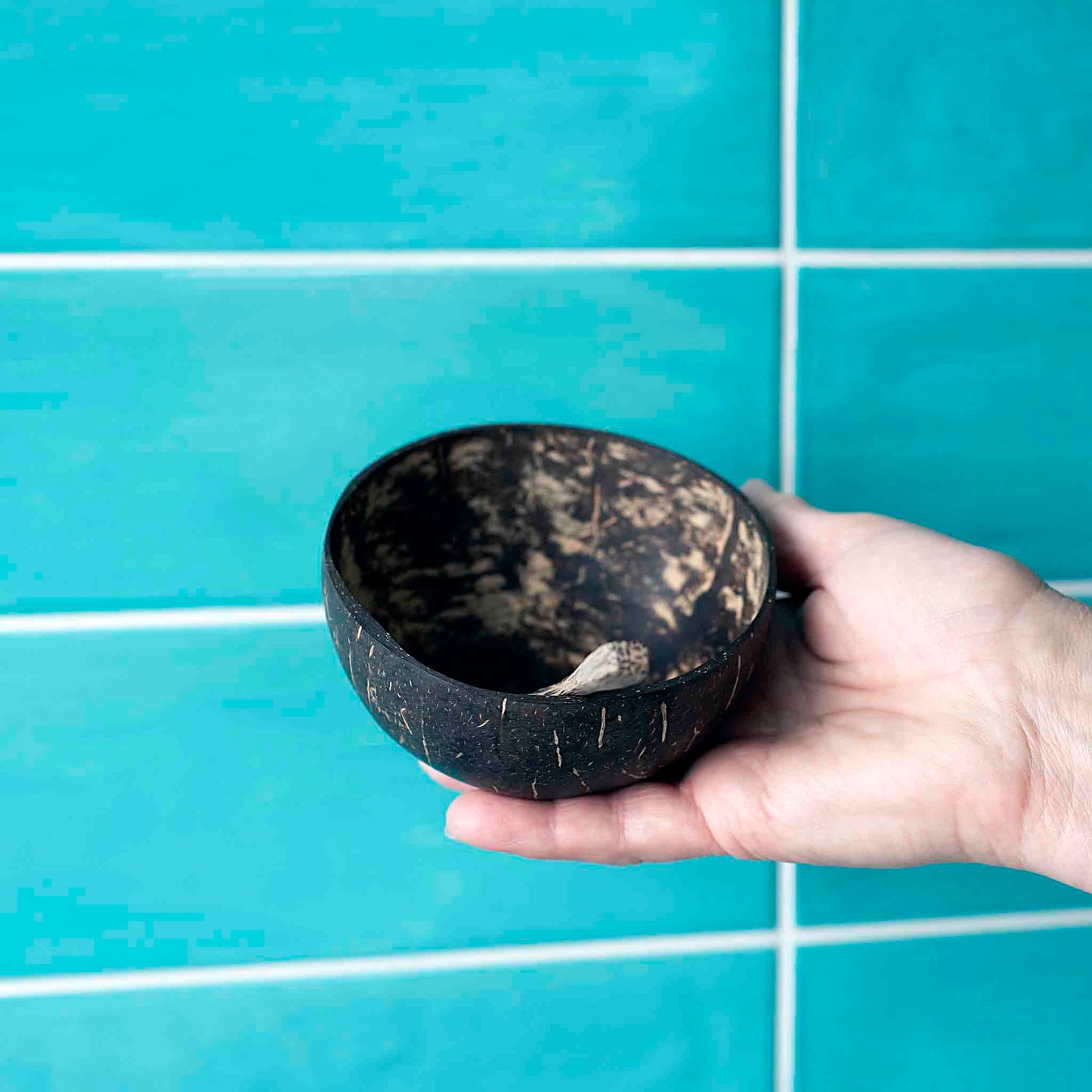 Tvarus kokoso dubuo su šaukšteliu rankoje – puikiai tinka užkandžiams.